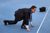 business man in suit getting ready to race on a track