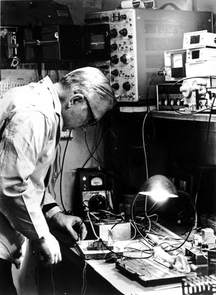 black and white photo of John Wiegand working on some hardware