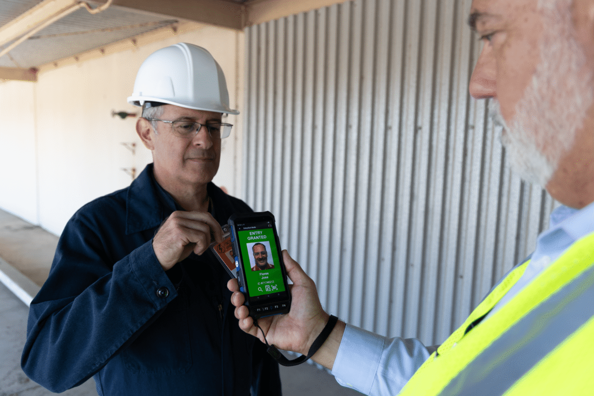 man scanning security ID card on a handheld badge reader